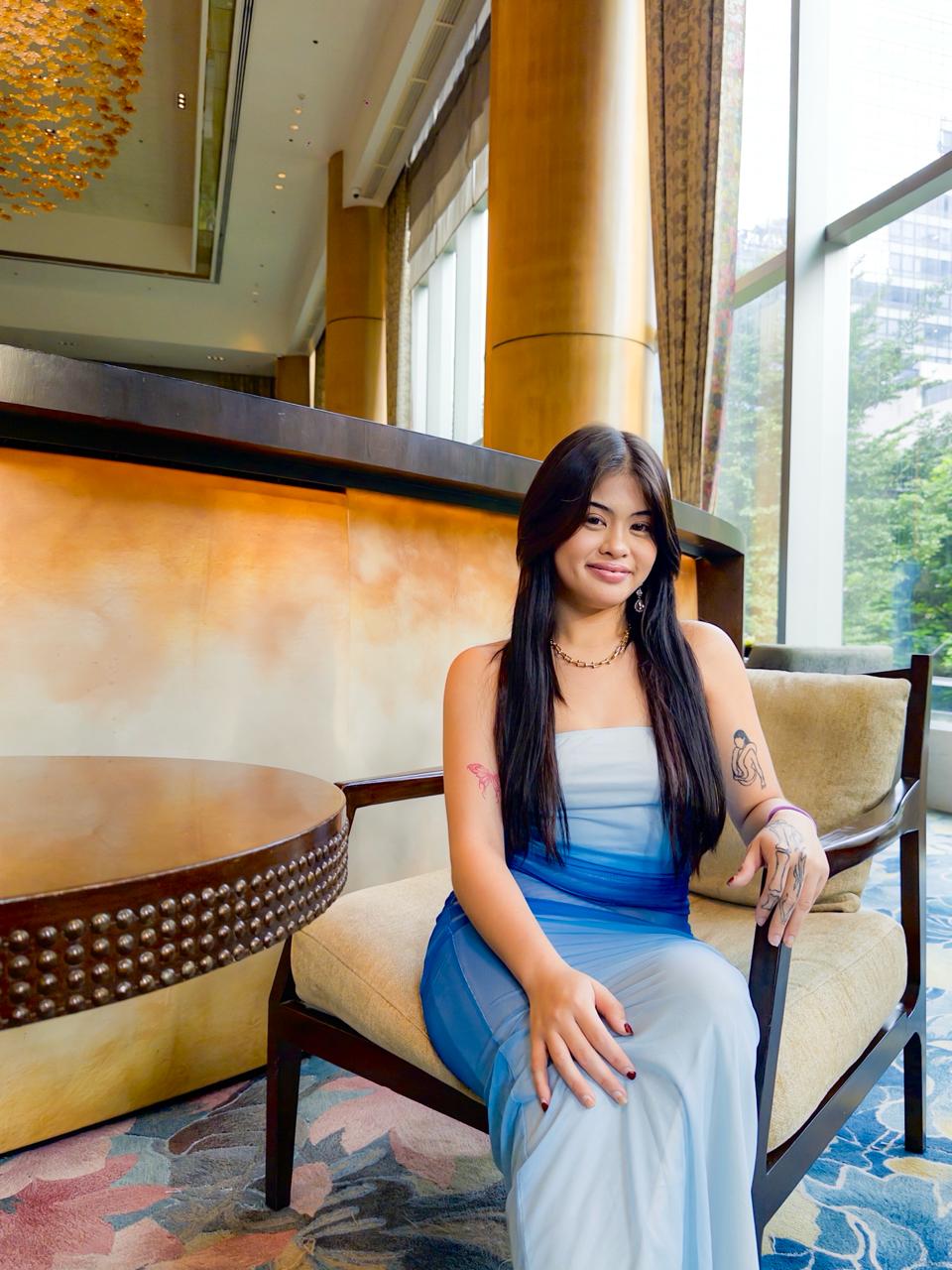Sienna seated gracefully in a blue dress at Shangri-La The Fort Lounge