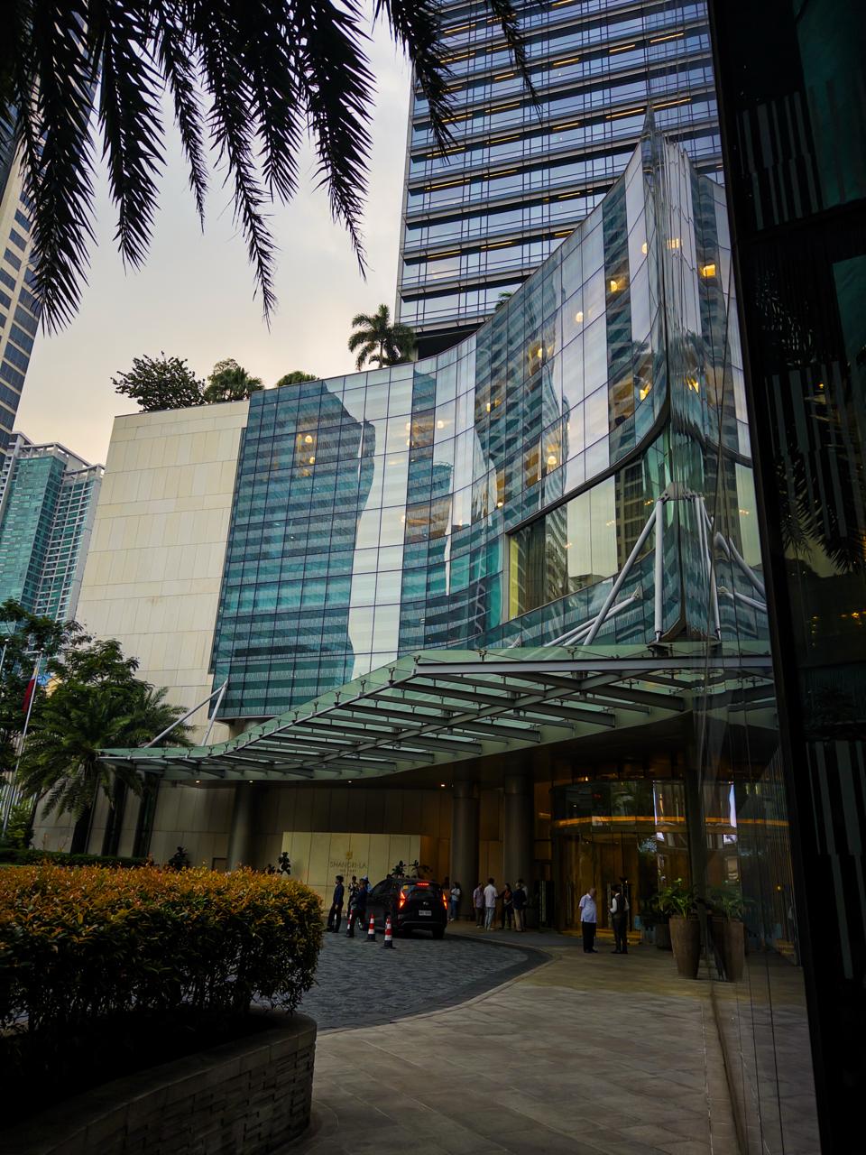 Shangri-La The Fort Manila main driveway and hotel facade surrounded by palm trees