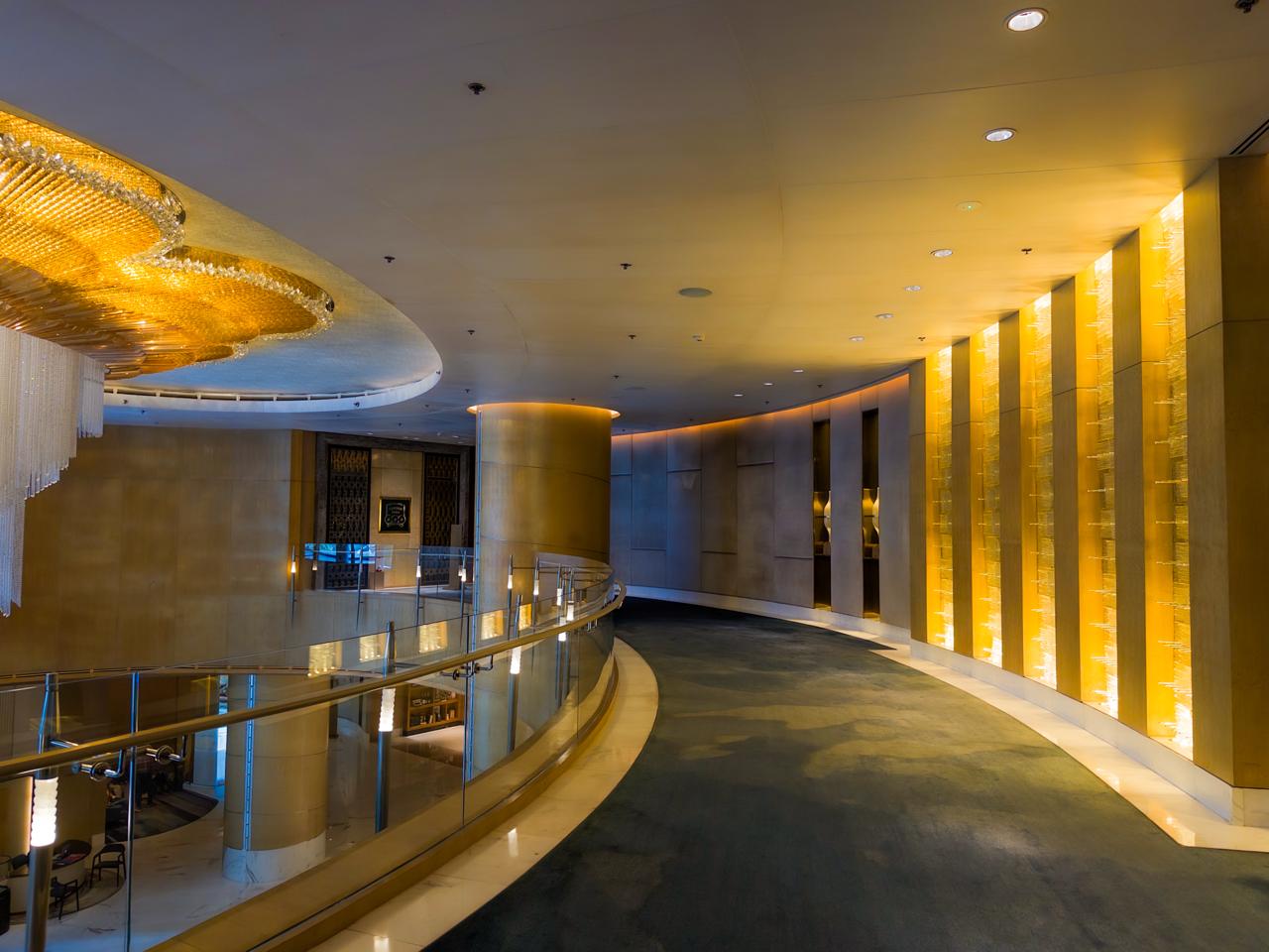 Curved golden corridor at Shangri-La The Fort Lounge with warm lighting and chandeliers